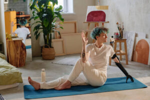 Curly girl with bionic arm doing twist pose on yoga mat